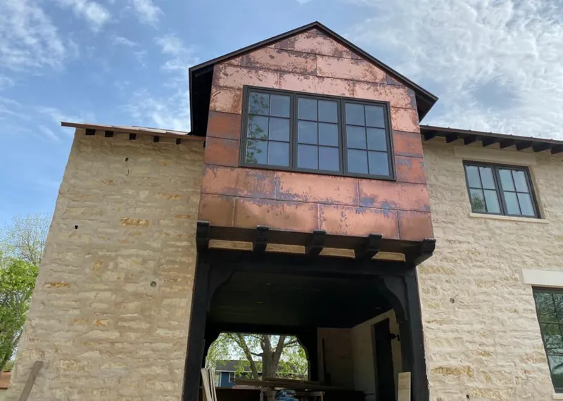 Copper metal panel facade on a stone building for Roof Repair in Oak Point